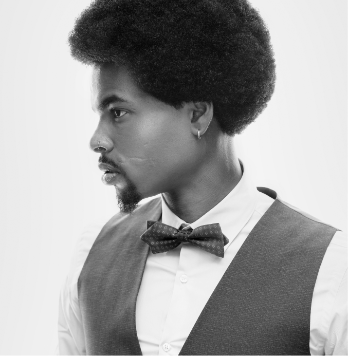 Stylish man with natural afro hair and bow tie – TheBarber.ch men's hair color and conditioning treatment Zurich