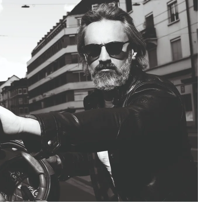 Bearded man with sunglasses on motorcycle in Zurich street – TheBarber.ch hand care filing massage and polishing service